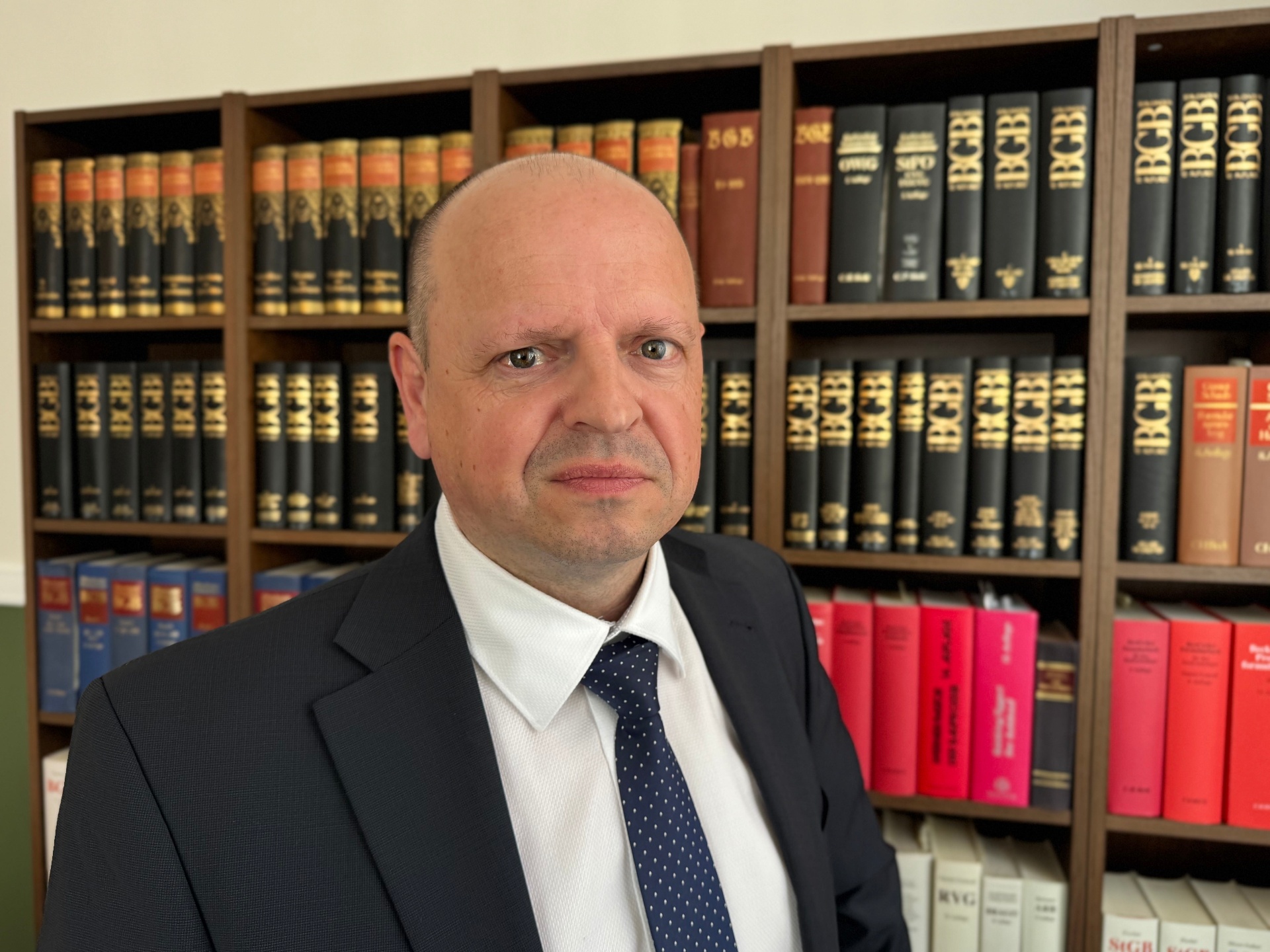 Portrait Rechtsanwalt Markus Tschiedel vor der Fachbibliothek der Kanzlei